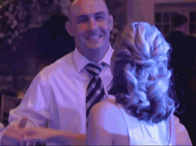 a man and a woman are dancing in a dark room