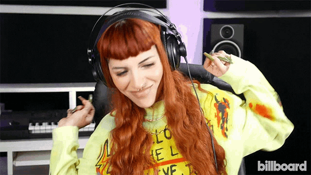 a woman wearing headphones and a shirt that says billboard on the front