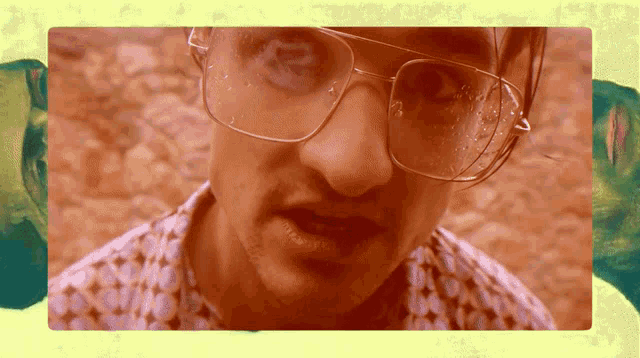 a close up of a man 's face with glasses