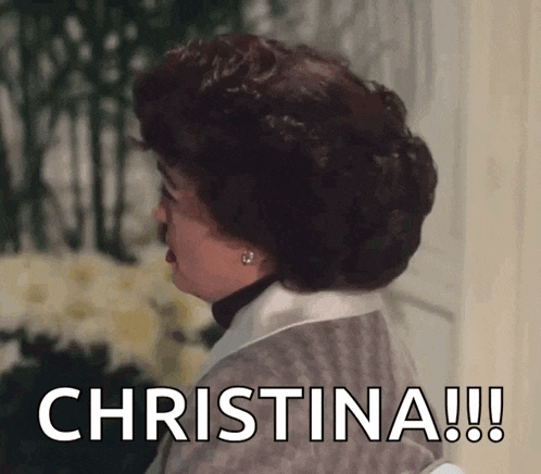 a woman with curly hair says christina !!! in front of flowers