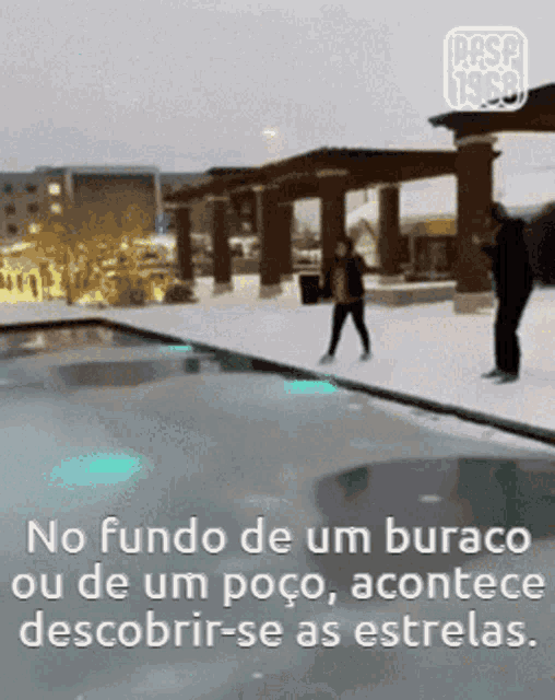 a man and a woman are standing next to a swimming pool covered in snow ..