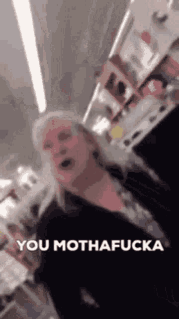 a woman is yelling at another woman in a store and says `` you motha fucka '' .