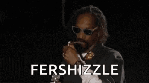 snoop dogg is smoking a marijuana pipe in a dark room .