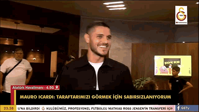 a man is smiling in front of a screen that says gstv