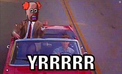 a man in a suit and tie is driving a red car with yrrrr written on the bottom