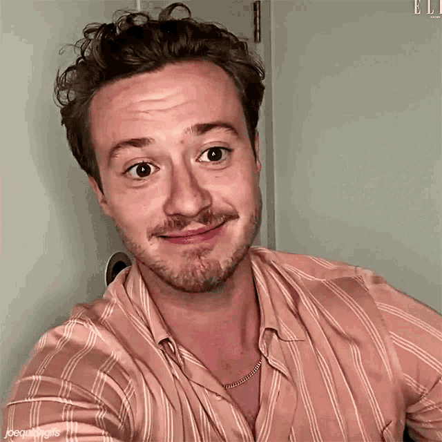 a man with a beard wearing a pink striped shirt
