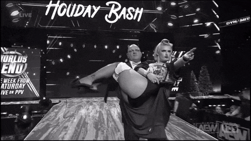 a black and white photo of a man carrying a woman on a stage with the words holiday bash in the background