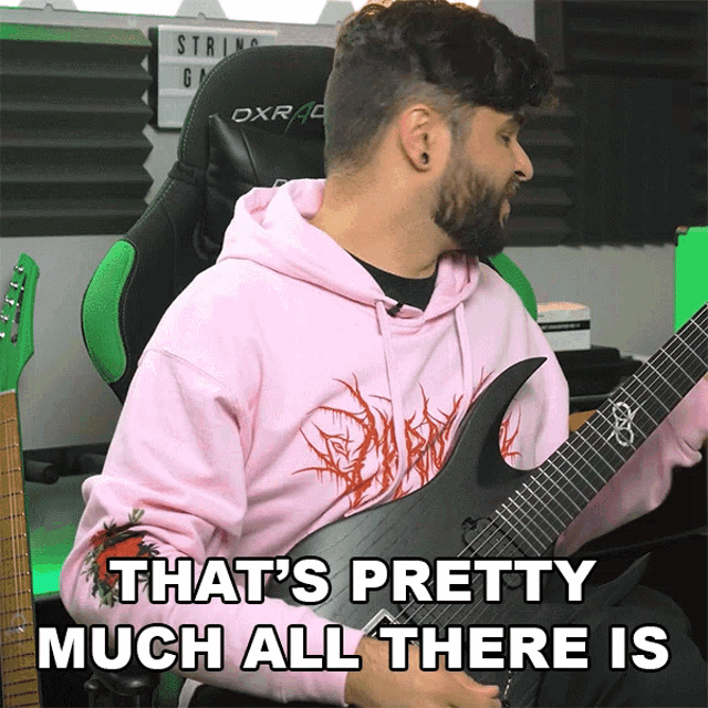a man in a pink hoodie holds a guitar and says " that 's pretty much all there is "