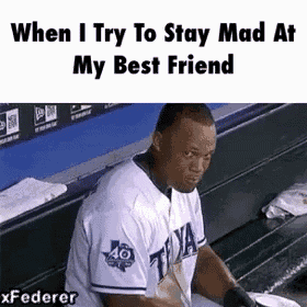 a baseball player is sitting on a bench in a dugout and making a funny face .