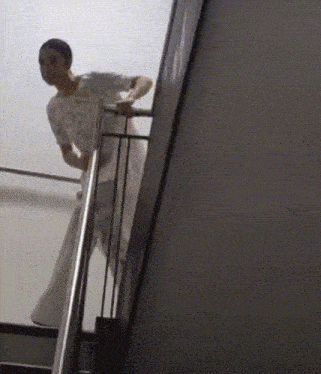 a man is walking up a set of stairs with a railing