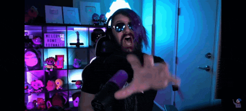 a man with purple hair and sunglasses is making a funny face in front of a sign that says welcome home roommate