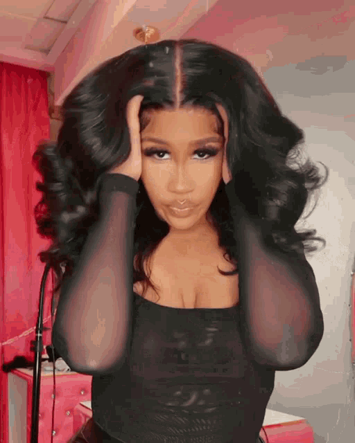 a woman in a black top is holding her head