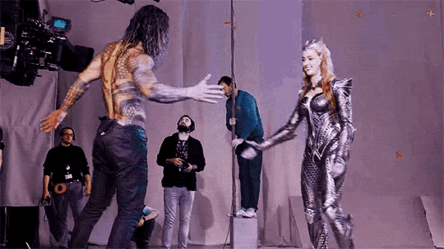a man and a woman are standing next to each other on a stage and holding hands .