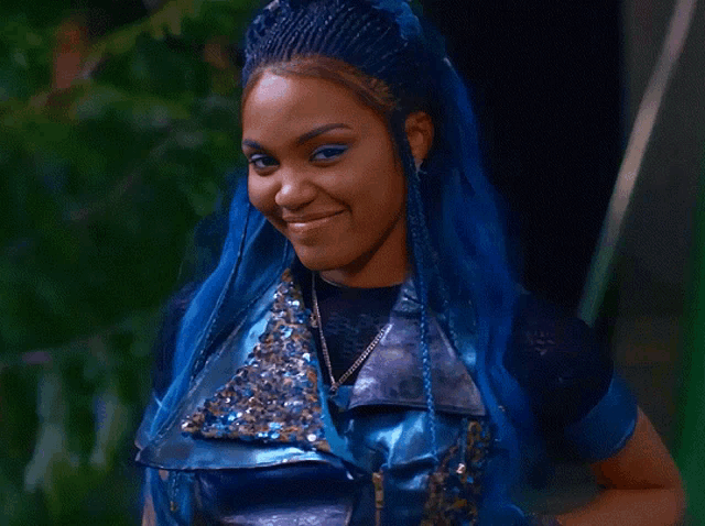 a woman with blue hair and braids is smiling