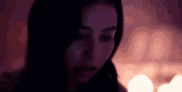 a close up of a woman 's face in a dark room .