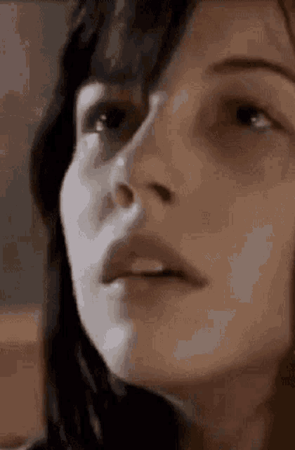 a close up of a woman 's face with her mouth open and her eyes looking up .