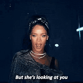a woman is standing in front of a mirror with the words `` but she 's looking at you '' written on it .