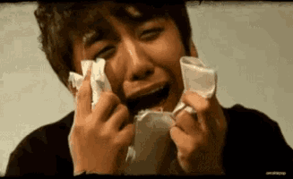 a man is crying while holding a napkin in his hand .