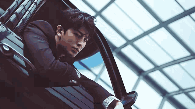 a man in a suit is leaning out of the window of a car