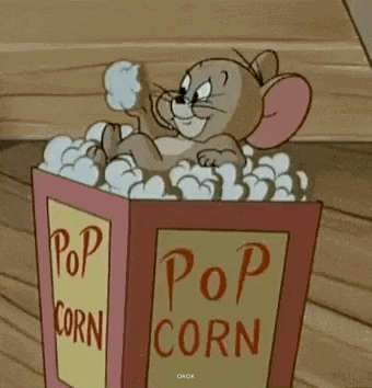 tom and jerry are sitting in a box of popcorn .