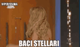 a woman is standing in front of a door and the words baci stellari are on the screen