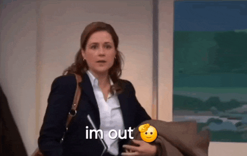 a woman in a suit and white shirt is sitting on a couch and says i 'm out .