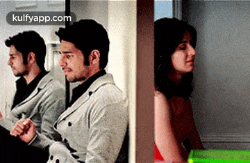 a man and a woman are sitting next to each other in a room