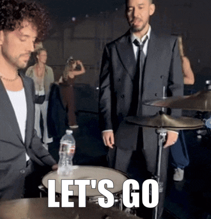 a man in a suit and tie playing drums with the words let 's go written below him