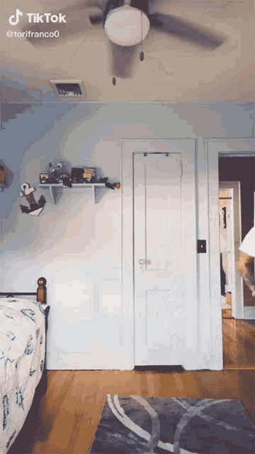a tiktok video of a bedroom with a ceiling fan and a dog