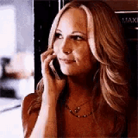a woman is talking on a cell phone in a room .