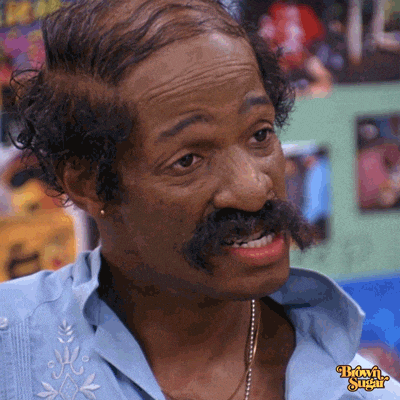 a man with a mustache is wearing a blue shirt with brown sugar written on it