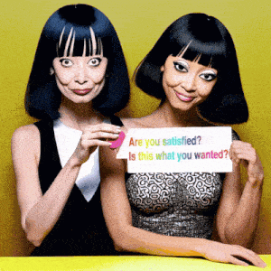 two women are holding a sign that says " are you satisfied "