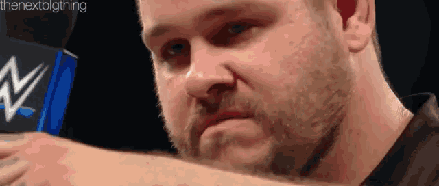 a close up of a man 's face with a beard and a black shirt .