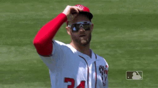 a baseball player is wearing sunglasses and a hat .
