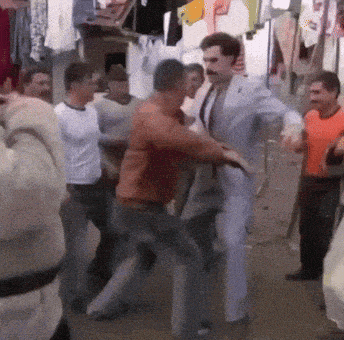 a man in a suit is dancing with other men