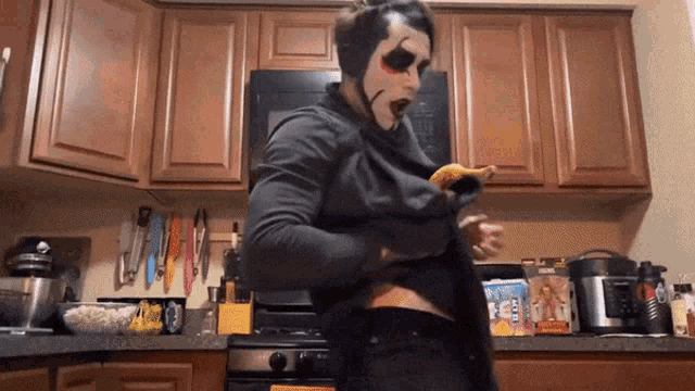 a person in a kitchen with a box of cheerios