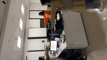 a group of people are standing around a desk with a computer monitor that says ' microsoft office ' on it