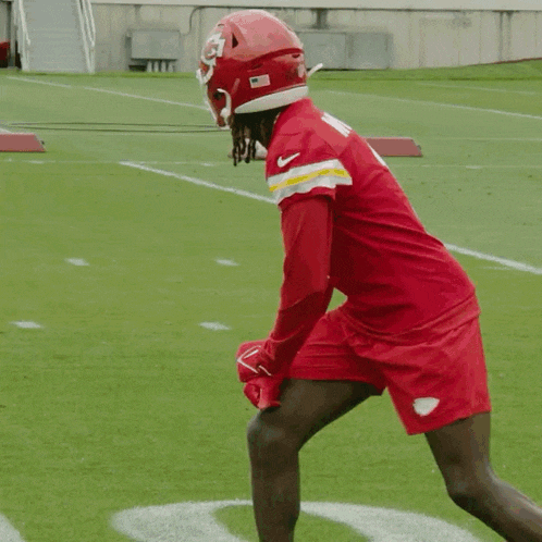 a football player in a red uniform with the number 1 on the back is running on a field .