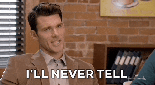 a man in a suit says " i 'll never tell " in front of a brick wall