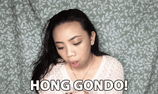 a woman says hong condo in front of a green leafy background