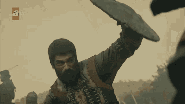 a tv screen shows a man holding a sword in front of a forest