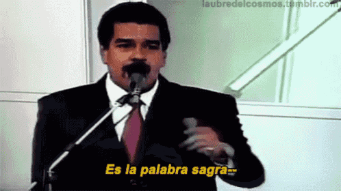 a man in a suit and tie speaking into a microphone with the words es la palabra sagra