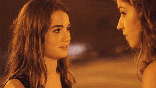 two women are looking into each others eyes at night