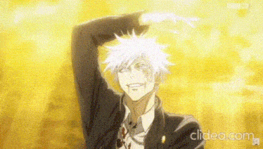 a man in a suit and tie is smiling and making a heart shape with his hand .