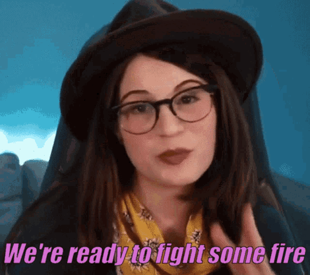 a woman wearing glasses and a hat is ready to fight some fire