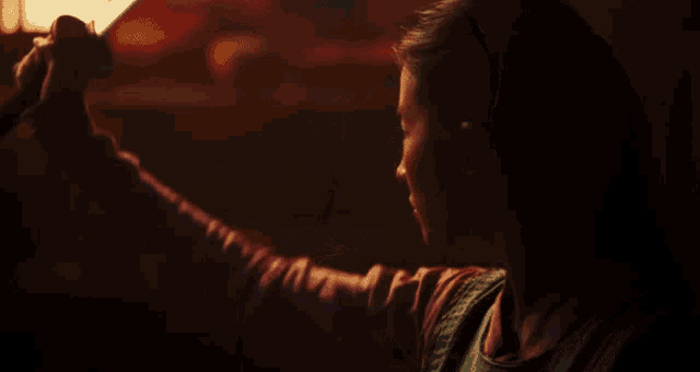 a woman is holding a sword in her hand in a dark room .