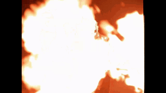 a man in a suit stands in front of a fire