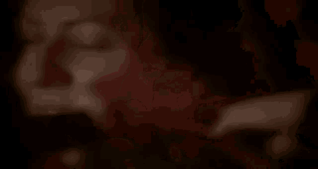 a close up of a woman 's face with red hair in a dark room with her eyes closed .