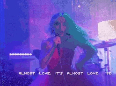 a woman in a red dress singing into a microphone with the words almost love it 's almost love