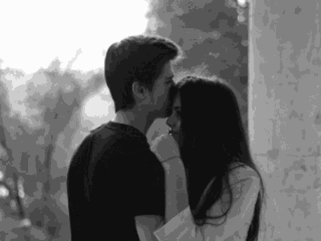 a man kissing a woman on the cheek in a black and white photo